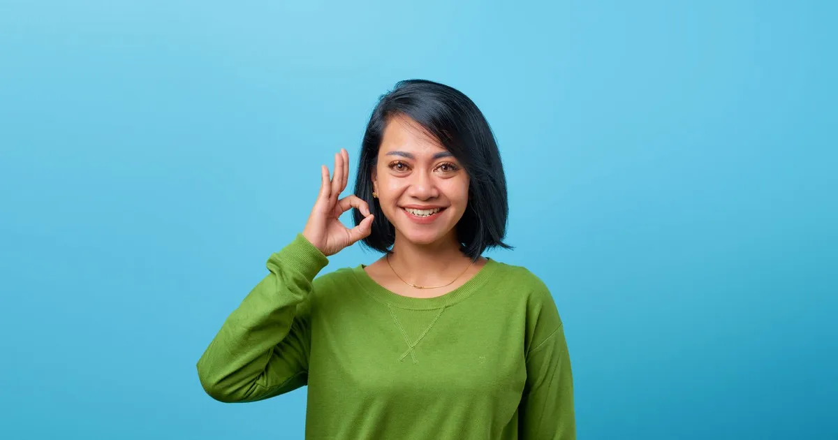 Smiling woman reading a guaranteed payday loans approval message on her phone at home