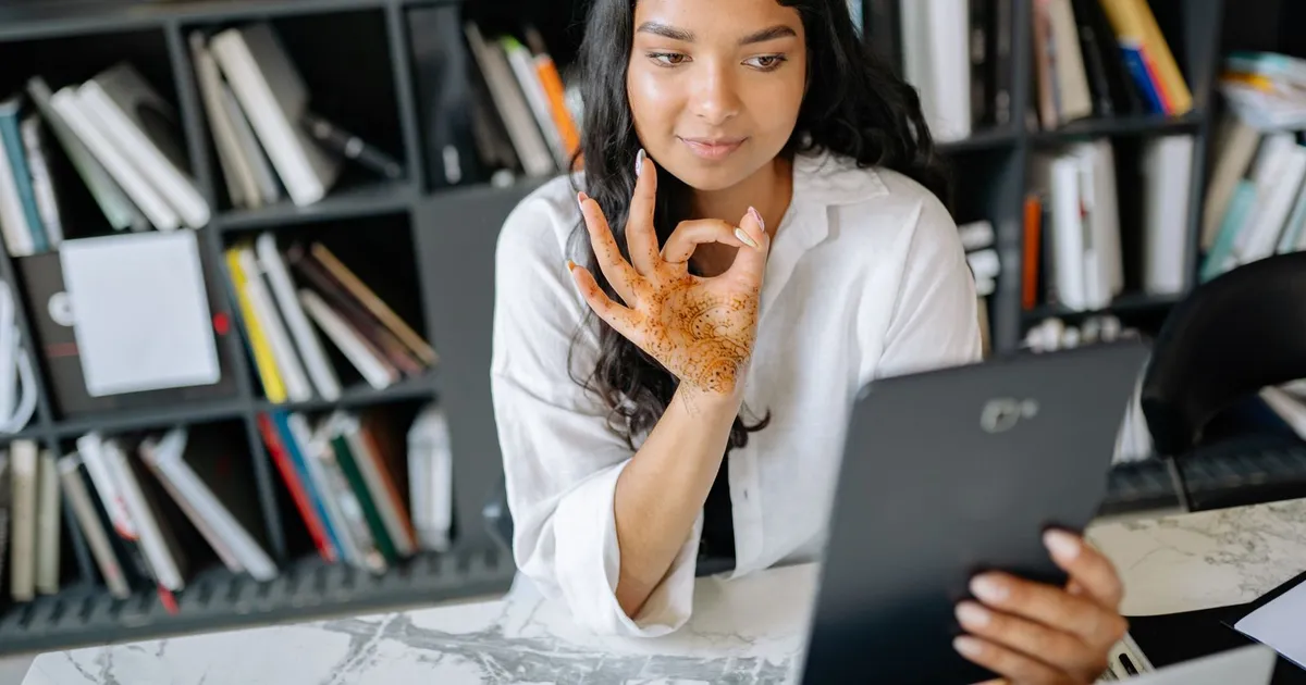 Relieved woman at her laptop after a no refusal payday loans approval in her kitchen