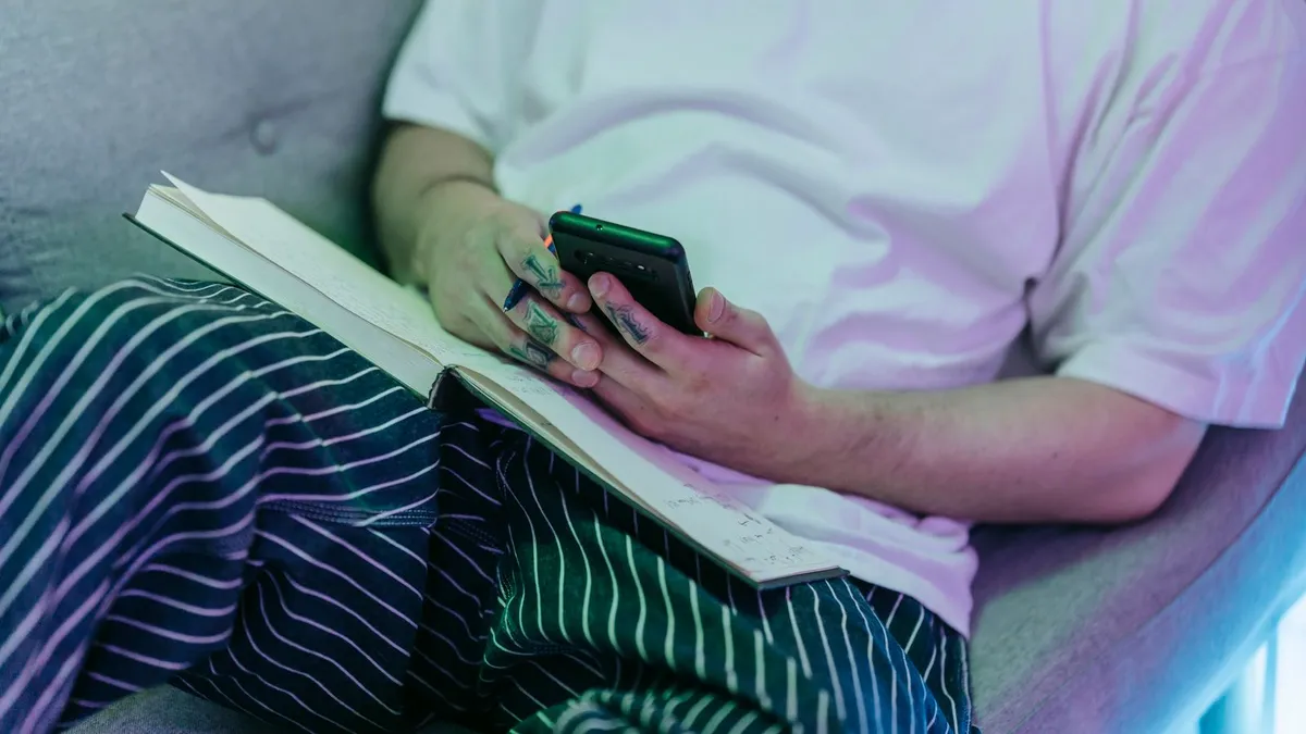 Person on a sofa completing a paperless payday loan application on a phone
